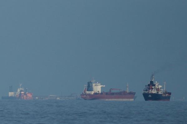 Oil tankers and cargo ships line up in the Strait of Hormuz as seen from Khor Fakkan, United Arab Emirates, on March 11, 2026. (AP-Yonhap)