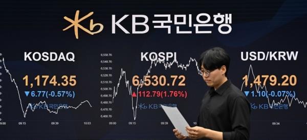 Traders at KB Securities in Seoul monitor the market on April 23, after the Kospi broke through 6,500 points, following a tech-led surge from Wall Street and stellar performance by SK hynix. (The Korea Herald)